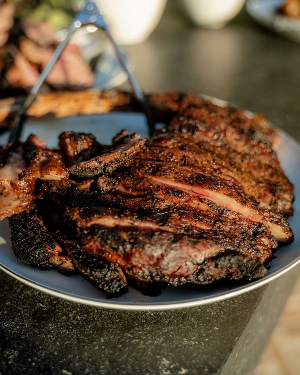 Sliced live-fire ribeye on a platter